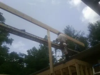 Carpenter setting a ridge beam over a new addition frame — Ice Dam Removal by Roofing Brothers in Yonkers