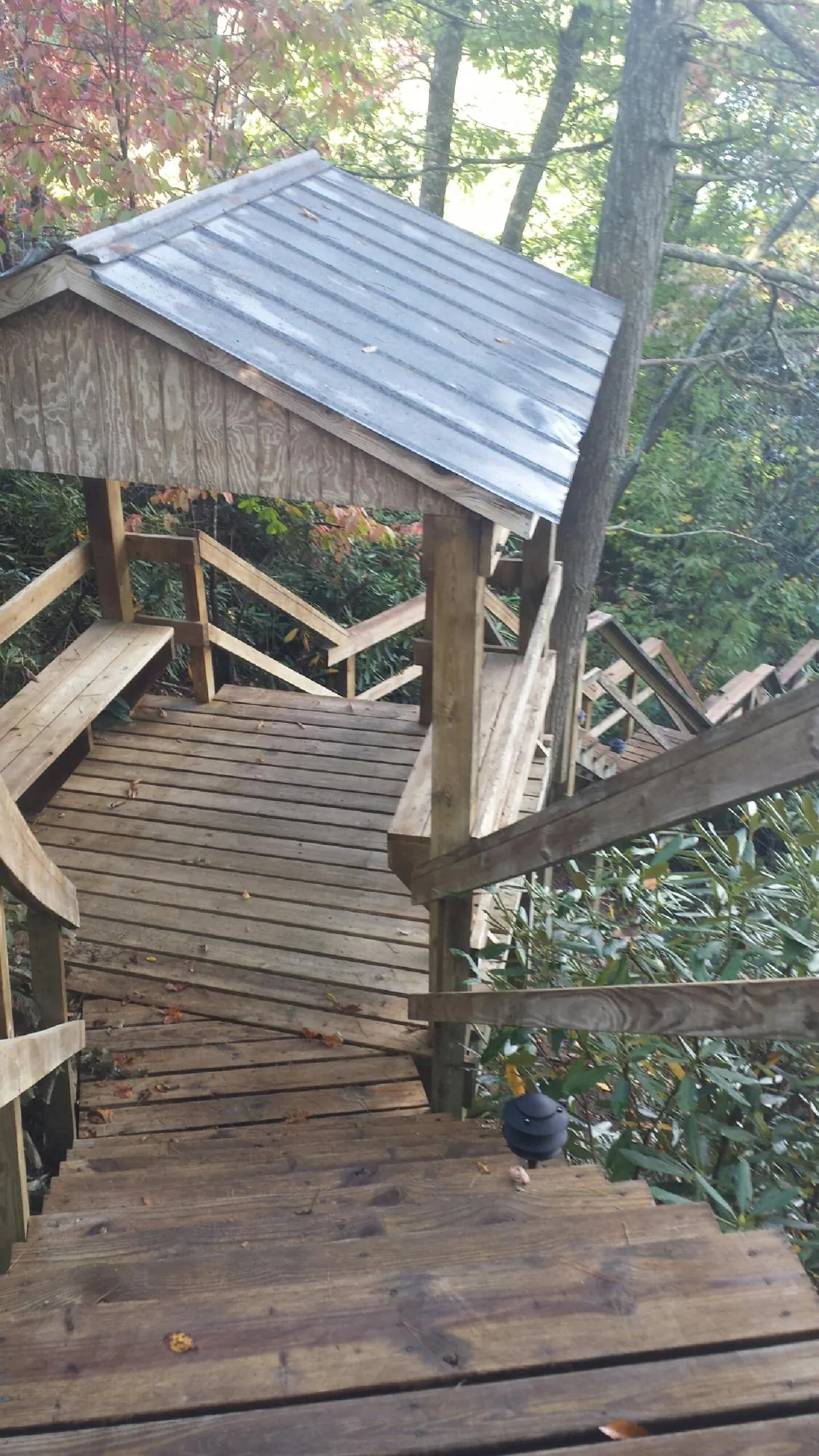 Metal roofed shelter over wooden steps on a wooded walkway — Skylight Repair & Installation work by our crew in Yonkers