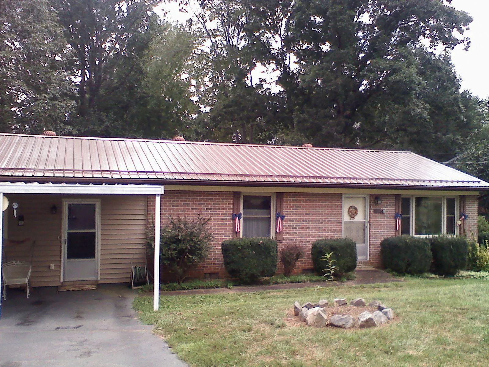 Bronze metal roof and carport on a brick ranch home — Roof Repair work by our crew in Yonkers